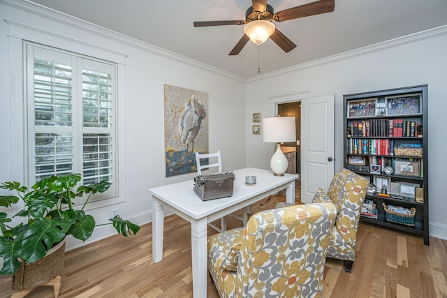 home office featuring light wood finished floors, baseboards, crown molding, and a ceiling fan