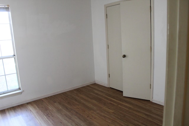 unfurnished room with dark hardwood / wood-style flooring