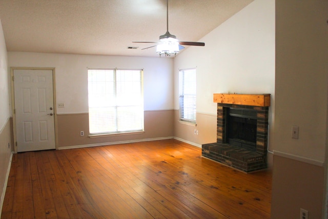 unfurnished living room featuring a fireplace, hardwood / wood-style flooring, and ceiling fan