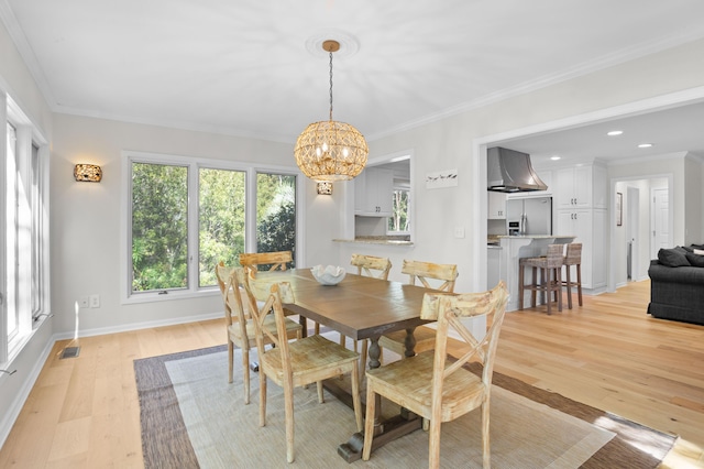 dining room featuring a chandelier, visible vents, light wood-style floors, and ornamental molding