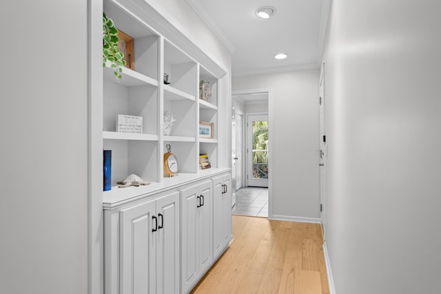 hallway featuring recessed lighting, light wood-type flooring, baseboards, and crown molding