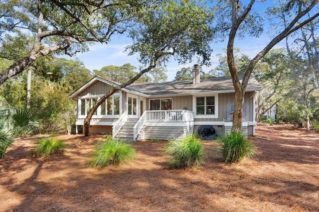 rear view of property with stairway, board and batten siding, and a deck