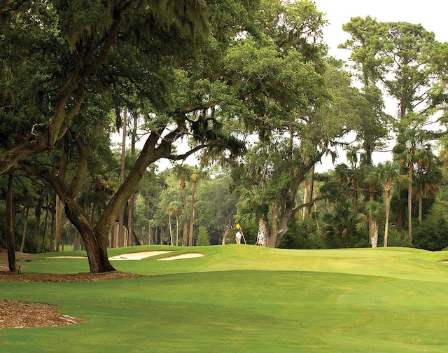 surrounding community featuring a lawn and golf course view