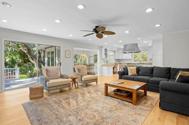 living area with recessed lighting, light wood-style flooring, a ceiling fan, and ornamental molding