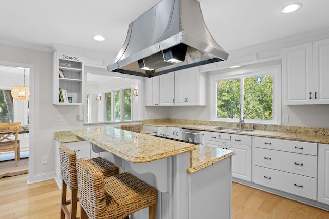 kitchen featuring a center island, light wood-style flooring, island exhaust hood, and a sink