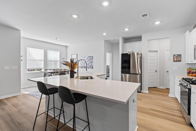 68 Red Bluff St, Summerville, SC 29483 - kitchen with a sink, light wood finished floors, a breakfast bar area, stainless steel appliances, and visible vents