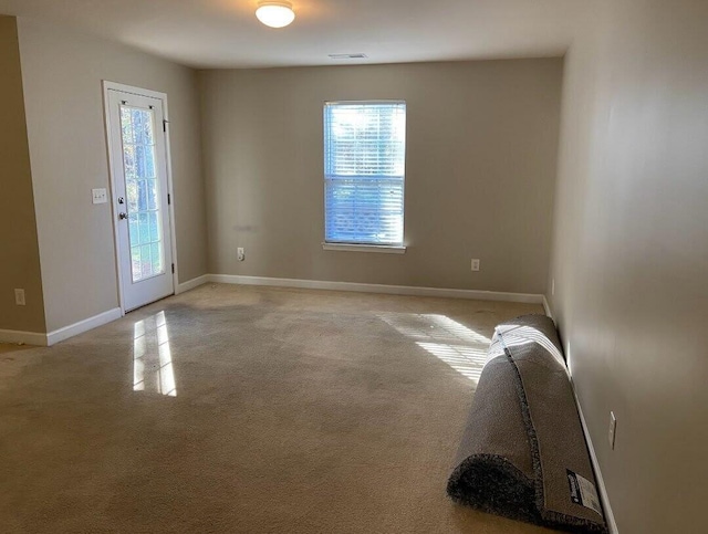 empty room with baseboards and light colored carpet