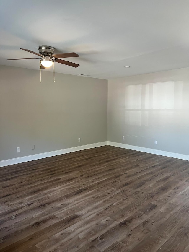 spare room with dark wood-type flooring and ceiling fan