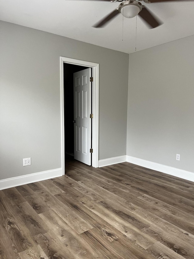 empty room with ceiling fan and dark hardwood / wood-style flooring