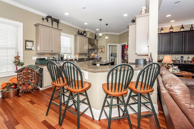 kitchen with range, light wood-type flooring, a peninsula, a breakfast bar, and recessed lighting