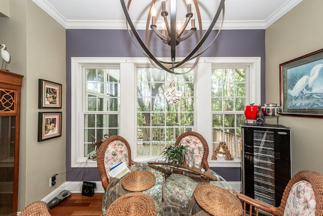 dining area with an inviting chandelier, baseboards, crown molding, and wood finished floors