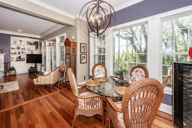 dining room featuring an inviting chandelier, wine cooler, wood finished floors, and a wealth of natural light