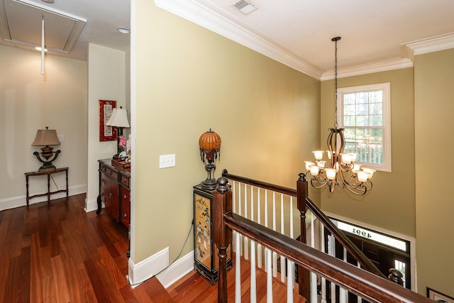 hallway with visible vents, ornamental molding, attic access, dark wood finished floors, and an upstairs landing