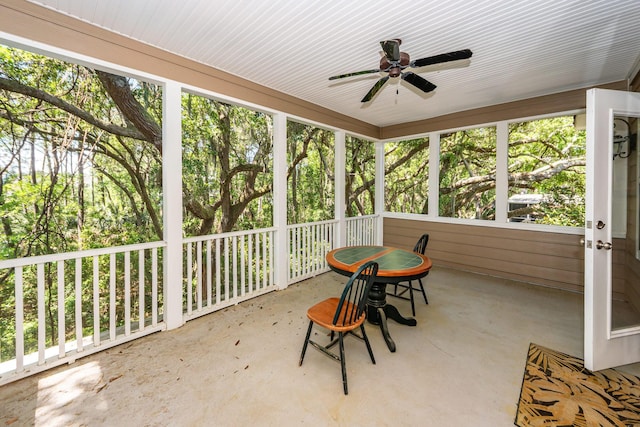 unfurnished sunroom with a ceiling fan