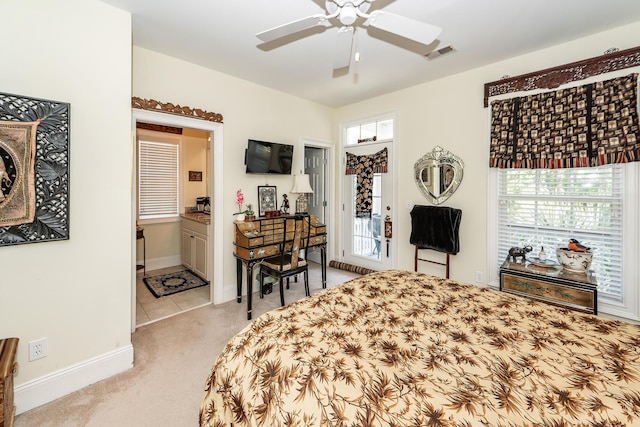 bedroom featuring visible vents, light carpet, baseboards, a ceiling fan, and ensuite bath
