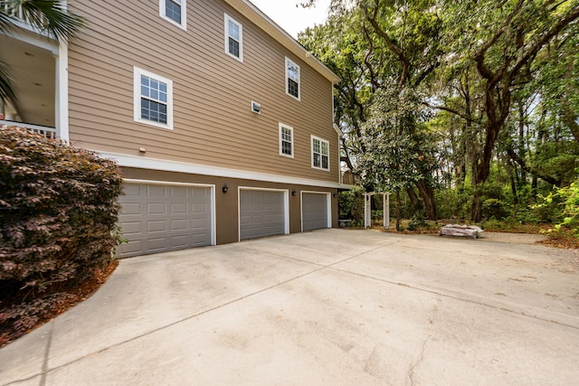 view of property exterior with an attached garage, driveway, and stucco siding