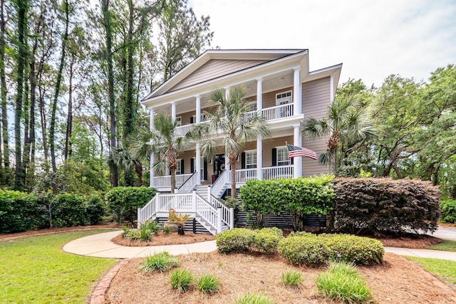 view of front of home with a porch, stairway, and a balcony