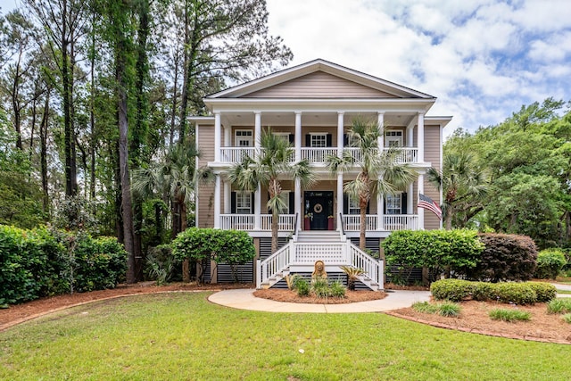 view of front of house with covered porch, stairs, a front lawn, and a balcony
