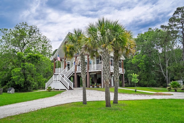 1064 Blackbear Dr, Edisto Island, SC 29438 - coastal home featuring a porch, curved driveway, stairway, and a front yard