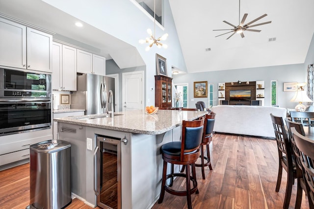 1064 Blackbear Dr, Edisto Island, SC 29438 - kitchen with wine cooler, appliances with stainless steel finishes, high vaulted ceiling, an island with sink, and wood finished floors