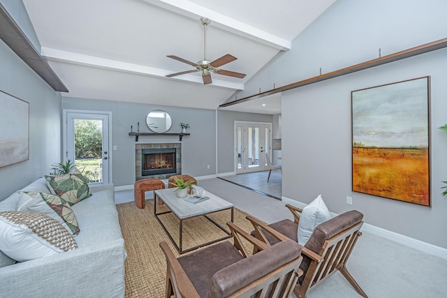 living area with beamed ceiling, carpet, baseboards, and a tile fireplace