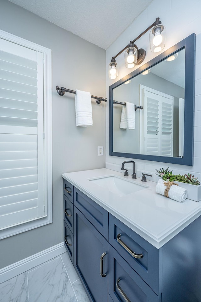 bathroom featuring a textured ceiling, marble finish floor, and vanity