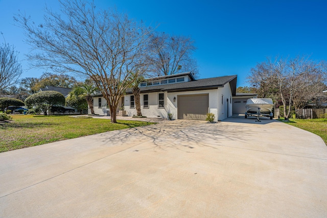 view of front of property featuring a front lawn, a garage, and driveway