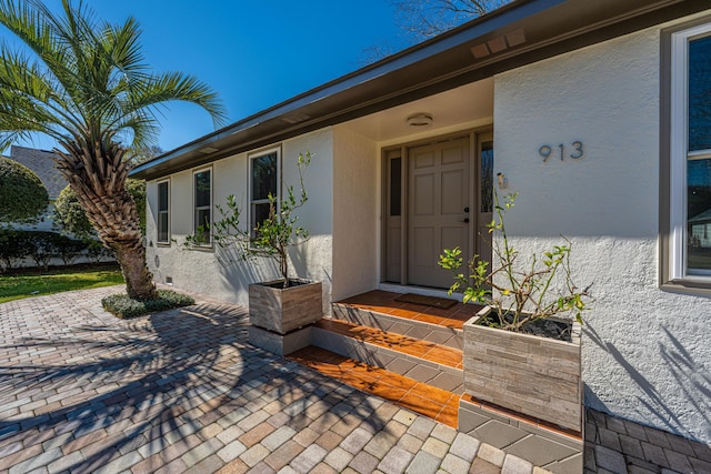 view of exterior entry featuring stucco siding