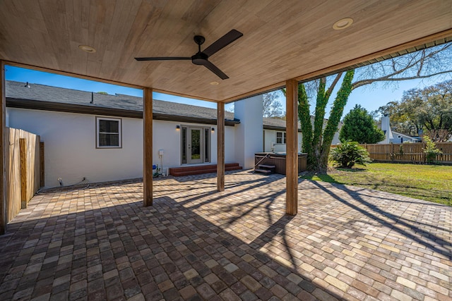 view of patio featuring a fenced backyard, a ceiling fan, and a hot tub