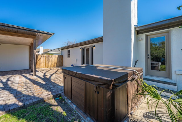 view of yard featuring a patio, fence, and a hot tub