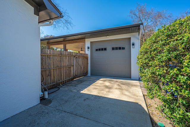 garage with driveway and fence