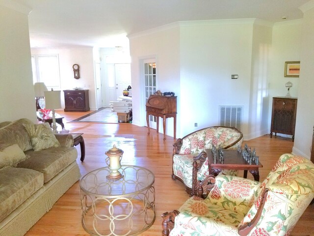 living room with crown molding and light hardwood / wood-style flooring