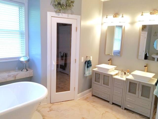 bathroom featuring vanity, a bathtub, and a wealth of natural light