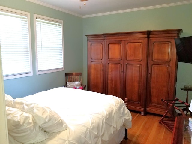 bedroom featuring light wood-type flooring and crown molding