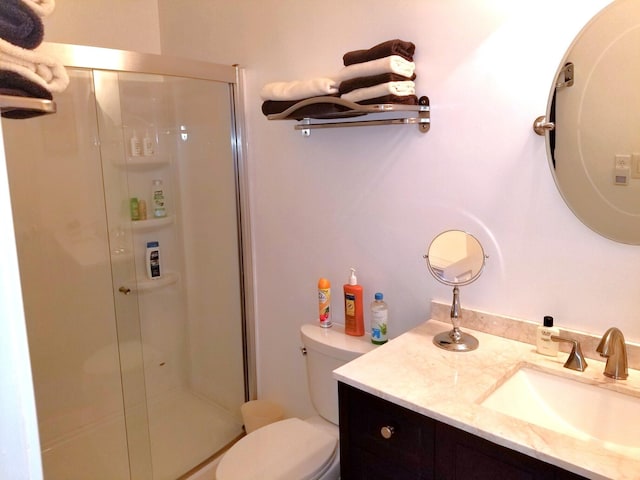 bathroom with an enclosed shower, toilet, and vanity