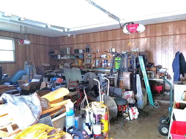 garage with a garage door opener and wooden walls