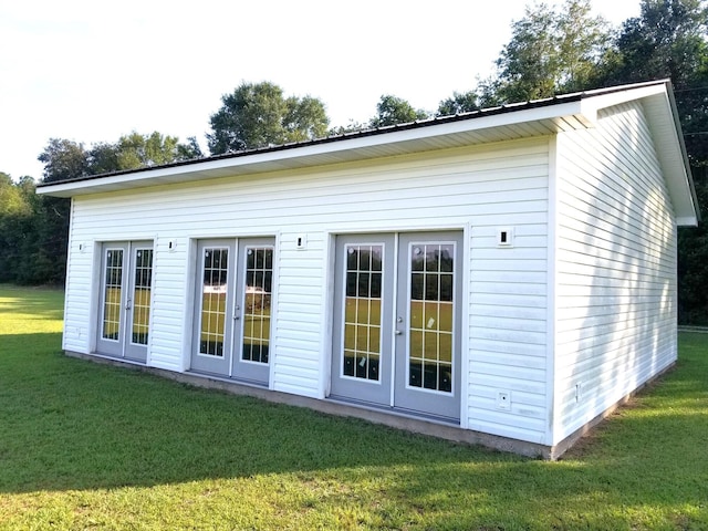 view of outdoor structure with french doors and a lawn