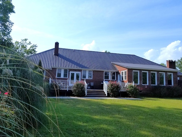 rear view of house with a yard, french doors, and a deck