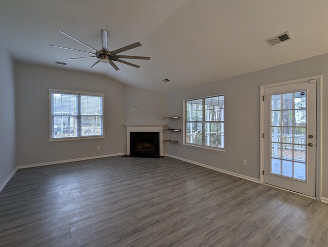 unfurnished living room featuring a healthy amount of sunlight, a fireplace with flush hearth, and visible vents