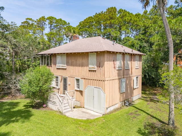 rear view of property featuring a lawn