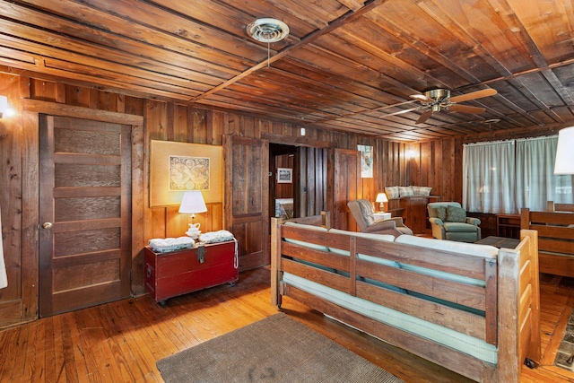 bedroom with wooden walls, hardwood / wood-style floors, and wood ceiling