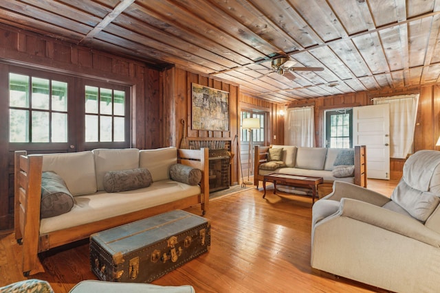 living room featuring a healthy amount of sunlight, wooden ceiling, and light hardwood / wood-style flooring