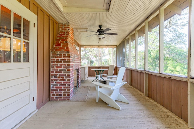 unfurnished sunroom with ceiling fan, plenty of natural light, and wood ceiling