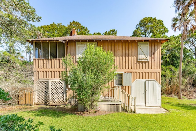 rear view of property with a sunroom and a lawn