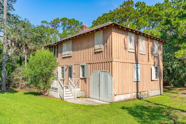 back of house featuring a lawn