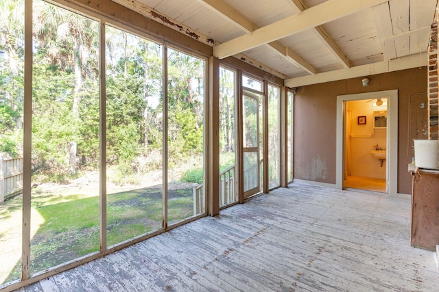 unfurnished sunroom with beamed ceiling