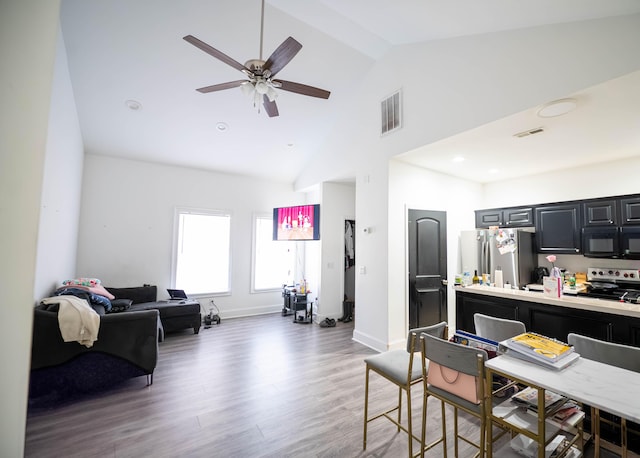 interior space with ceiling fan, high vaulted ceiling, and dark hardwood / wood-style flooring