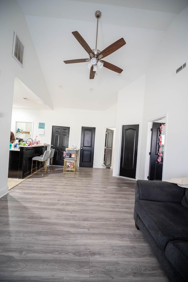 living room featuring ceiling fan, wood-type flooring, and high vaulted ceiling