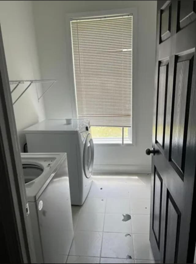 washroom featuring separate washer and dryer and light tile patterned flooring