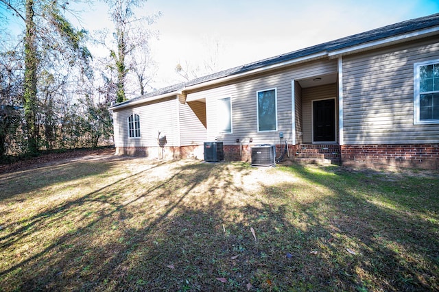 rear view of house with a yard and central air condition unit